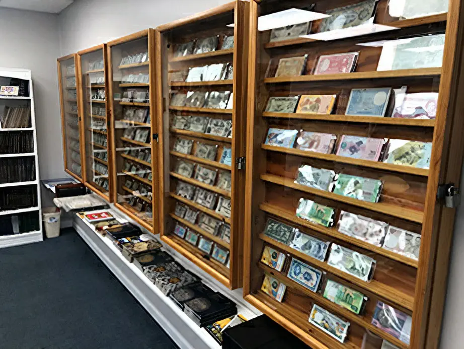 Row of wooden currency cases holding foreign banknotes at Kansas Coin Connection